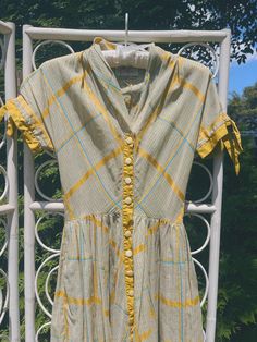 This dress was made by Carlye in the late 1940s or early 1950s. It features beautiful mustard yellow and robin's egg blue plaid -- but looks like a light greenish gray with yellow accents from a distance. It buttons up the front center. Fits similar to a modern XXS/XS. Please review measurements below. Measurements Bust: 30 inches Waist: 24 inches Length: 46 inches Condition: Excellent vintage condition. The only flaw is that the original belt, which is included, may be missing a piece. That is, I can't figure out how it is supposed to be fastened, but you might! The dress itself is pristine. If you have any questions or need additional photos or measurements, please let me know. I'm happy to help! Thank you so much for shopping with Chloris Vintage. --Chandler Retro Plaid Dresses For Vintage Fashion, Retro Plaid Dress For Picnic, Retro Gingham Vintage Dress, Fitted Retro Plaid Dress For Spring, Fitted Vintage Plaid Dress, Vintage Fitted Plaid Dress For Picnic, Fitted Vintage Plaid Dress For Picnic, Yellow Retro Vintage Dress For Garden Party, Yellow Vintage Dress For Garden Party