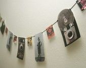 a camera hanging from a string with pictures on it