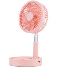 a pink desk fan sitting on top of a table