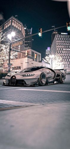 a futuristic car is driving down the street at night with city lights in the background