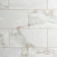 white marble tile with gold veining on the bottom and sides, in an irregular pattern