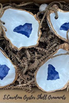 four decorative blue and white plates in a cardboard box with twine rope around them