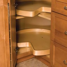 an open cabinet with wooden shelves and drawers in the corner, showing wood cupboards