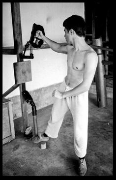 a shirtless man standing next to a machine