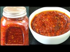 a bowl of chili sauce next to a glass jar