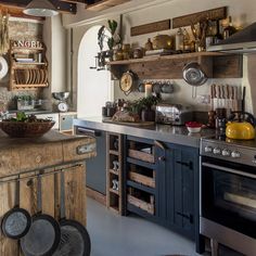 a kitchen with lots of wooden shelves filled with pots and pans on top of it