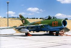 a fighter jet sitting on top of an airport tarmac