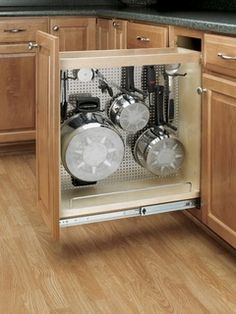 an open cabinet with pots and pans in it