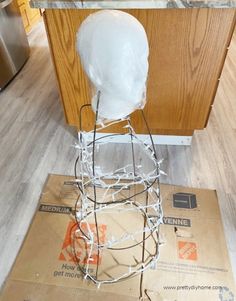 a white plastic head sitting on top of a cardboard box next to a countertop