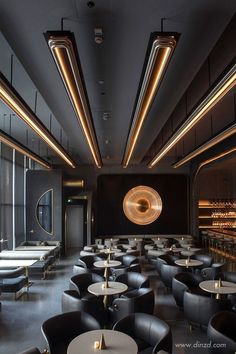 an empty restaurant with black leather chairs and gold accents