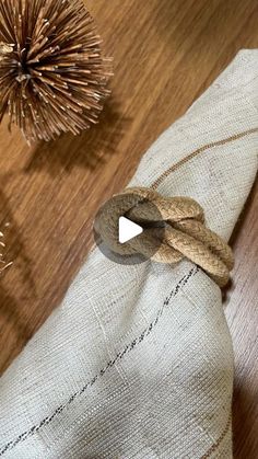 a piece of cloth on top of a wooden table next to two small pine cones