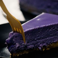 there is a piece of cake with purple icing on it and a fork in the middle