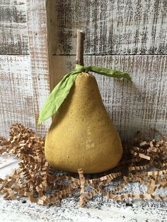 a yellow pear with a green leaf on it