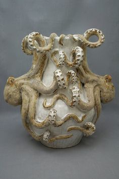 an octopus sculpture is on display against a gray background and it appears to be in the shape of a vase