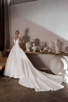 a woman in a wedding dress standing next to a table with vases on it