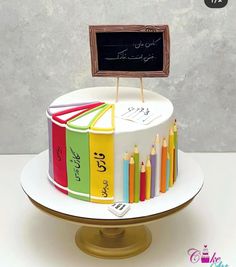 a multicolored cake with a chalkboard on top and colorful crayons