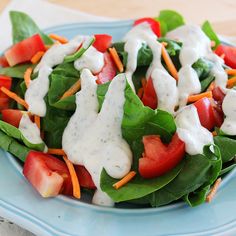 a blue plate topped with salad covered in dressing