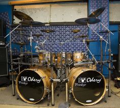 a set of drums sitting on top of a floor in front of a blue wall