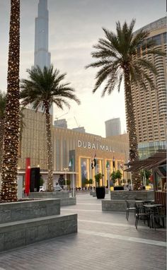 the palm trees are lit up in front of the burj mall