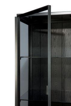 a black cabinet with glass doors on the front and bottom shelves is shown against a white background