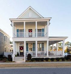 a white two story house with blue shutters and balconies on the second floor