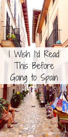 a woman sitting on a bench in an alley way with text overlay reading i wish i'd read this before going to spain