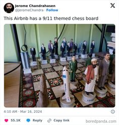 a chess board with figurines of people on it and one man standing in front of the board