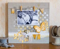 an altered picture frame with yellow and white butterflies on it, next to some spools of twine