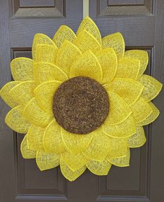 a yellow mesh sunflower is hanging on the front door