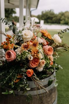 a wooden barrel filled with lots of flowers