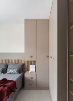 a bed sitting next to a closet in a bedroom