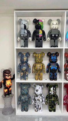 a shelf filled with lots of different colored teddy bears on top of white bookshelves