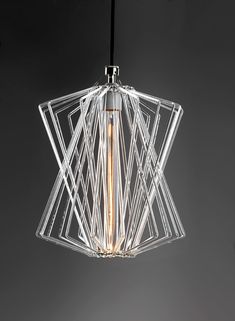 a light that is hanging from the ceiling in a room with black walls and flooring