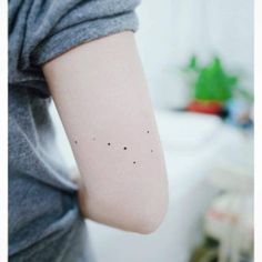 a woman's arm with small stars on it