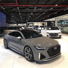 several cars are on display in a showroom at an automobile dealership, including the audi concept car