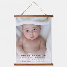 a wooden frame hanging on the wall with a baby in it's blanket and name