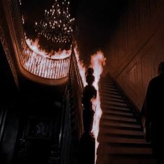 two people are walking down the stairs with fire coming from them