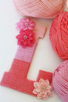 yarn and flowers are arranged next to the letter j, which is made from yarn