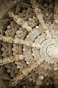 an intricately designed ceiling in the middle of a building with carvings on it's sides