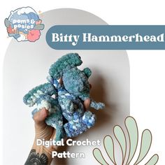 there is a small blue crocheted stuffed animal in someone's hand with the text, bitty hammerhead digital crochet pattern