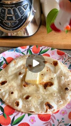 a tortilla on a colorful plate with a piece of butter in the middle