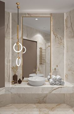 a bathroom with marble counter tops and gold fixtures on the wall, along with a large mirror