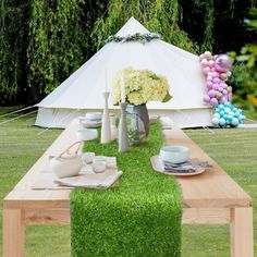 a table set up for a party with flowers and balloons in the backgroud