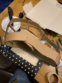 a cardboard box sitting on top of a wooden table next to scissors and other crafting supplies