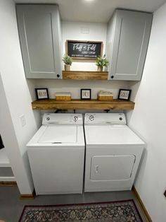 a washer and dryer in a laundry room with cabinets above the washer