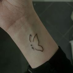 a small tattoo on the wrist of a woman with a butterfly in it's center