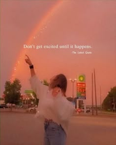 a woman standing in front of a rainbow with a quote on it that says don't get excited until it happens