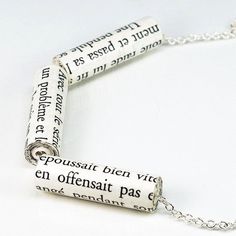 a close up of a necklace with words on it and a chain attached to it