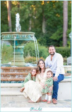 a family posing for a photo in front of a fountain