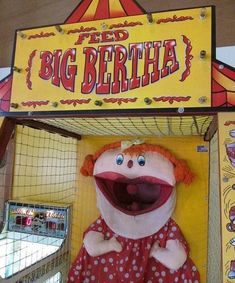 a large stuffed animal in front of a sign for the big bertha show at an amusement park